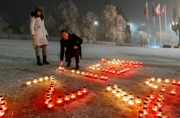 Rocznica Grudnia'70 w Szczecinie. Marszałek Olgierd Geblewicz schyla się, by zapalić znicz na placu Solidarności. Układa ostanią z kilkset lampek tworzących napis "Grudzień 70". Obok stoi Agnieszka Kuchcińska-Kurcz, kierownik Centrum Dialogu Przełomy.