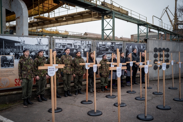 Symboliczne kryże upamiętniajace 16 ofiar Grudnia '70, w tle harcerze. 