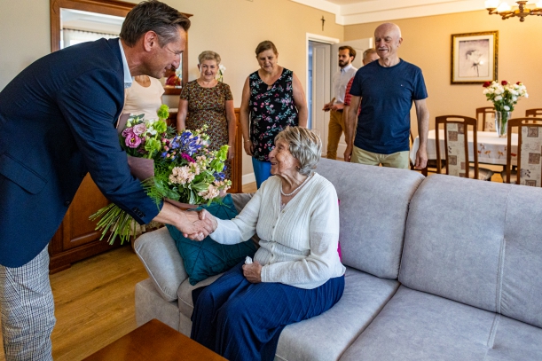 Marszałek Geblewicz wręcza bukiet kwiatów jubilatce. 