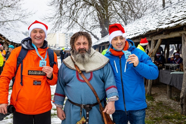 Rowwerzyści w wiosce Wikingów w Wolinie, w tle wioska. 