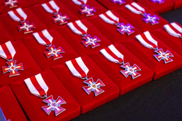 Odznaki Honorowe Gryfa Zachodniopomorskiego dla środowiska medycznego. Zestaw odznak leżący na stole.