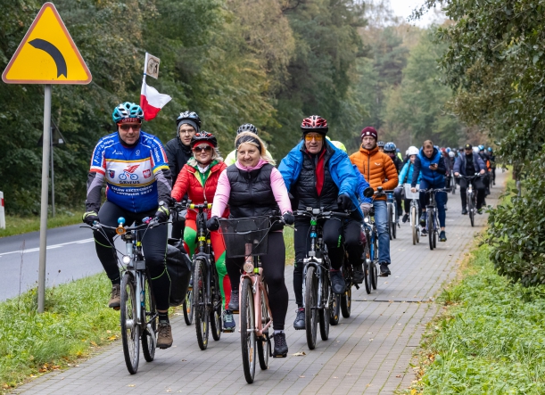 Rowerzyści na trasie, w tle ścieżka rowerowa, zieleń i droga wojewódzka nr 102. 