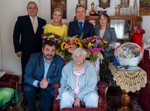 Goście urodzinowego przyjęcia pozują do wspólnego zdjecia z Lidią Więckowską.